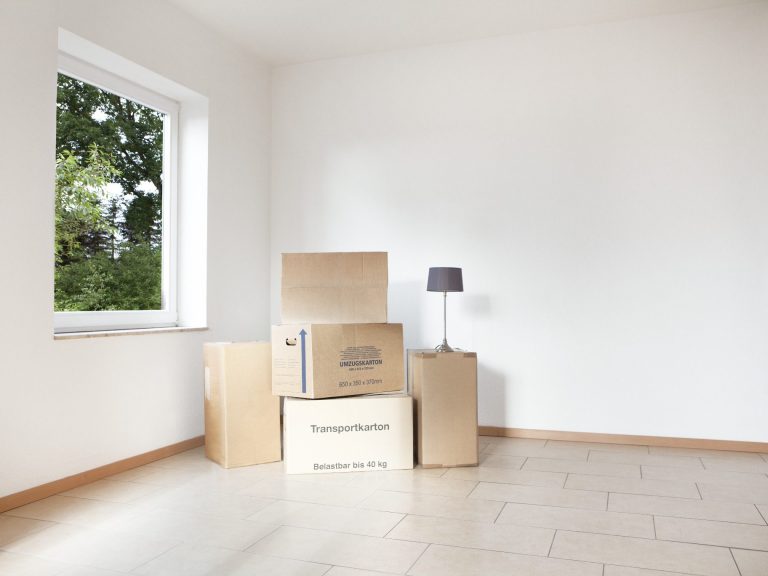 Entrümpelungen aller Art Sauberes Zimmer mit paar Kartons und weisse Wände