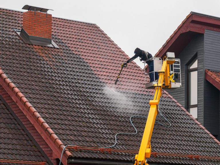 Dachreinigung Arbeiter auf reinigt Dachziegel mit dem Hochdruckreiniger